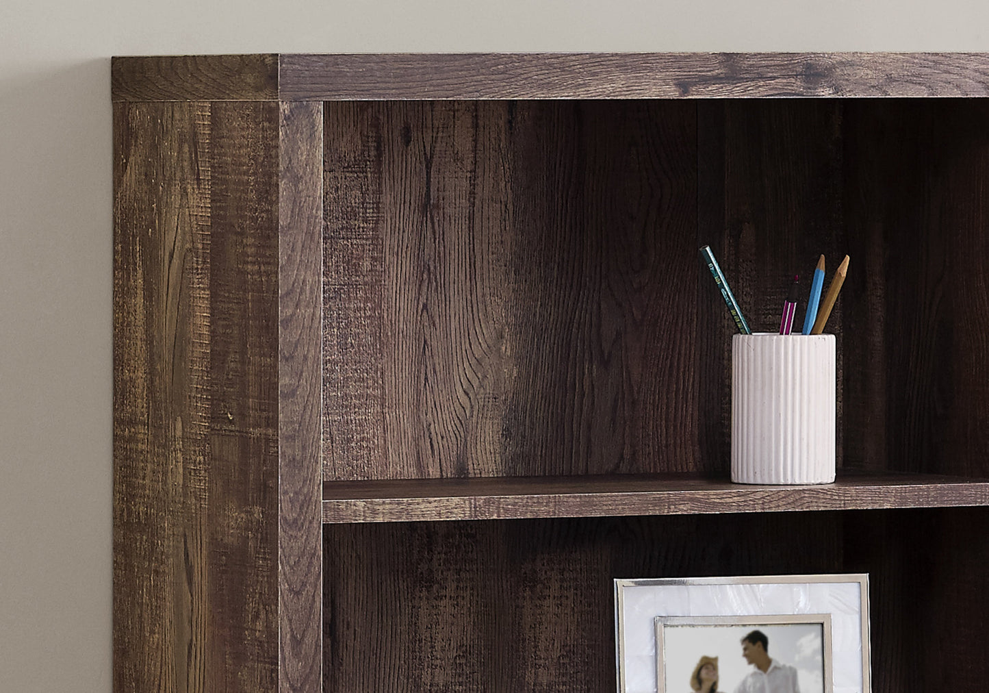 Rustic dark wood bookshelf detail with ribbed white pen holder