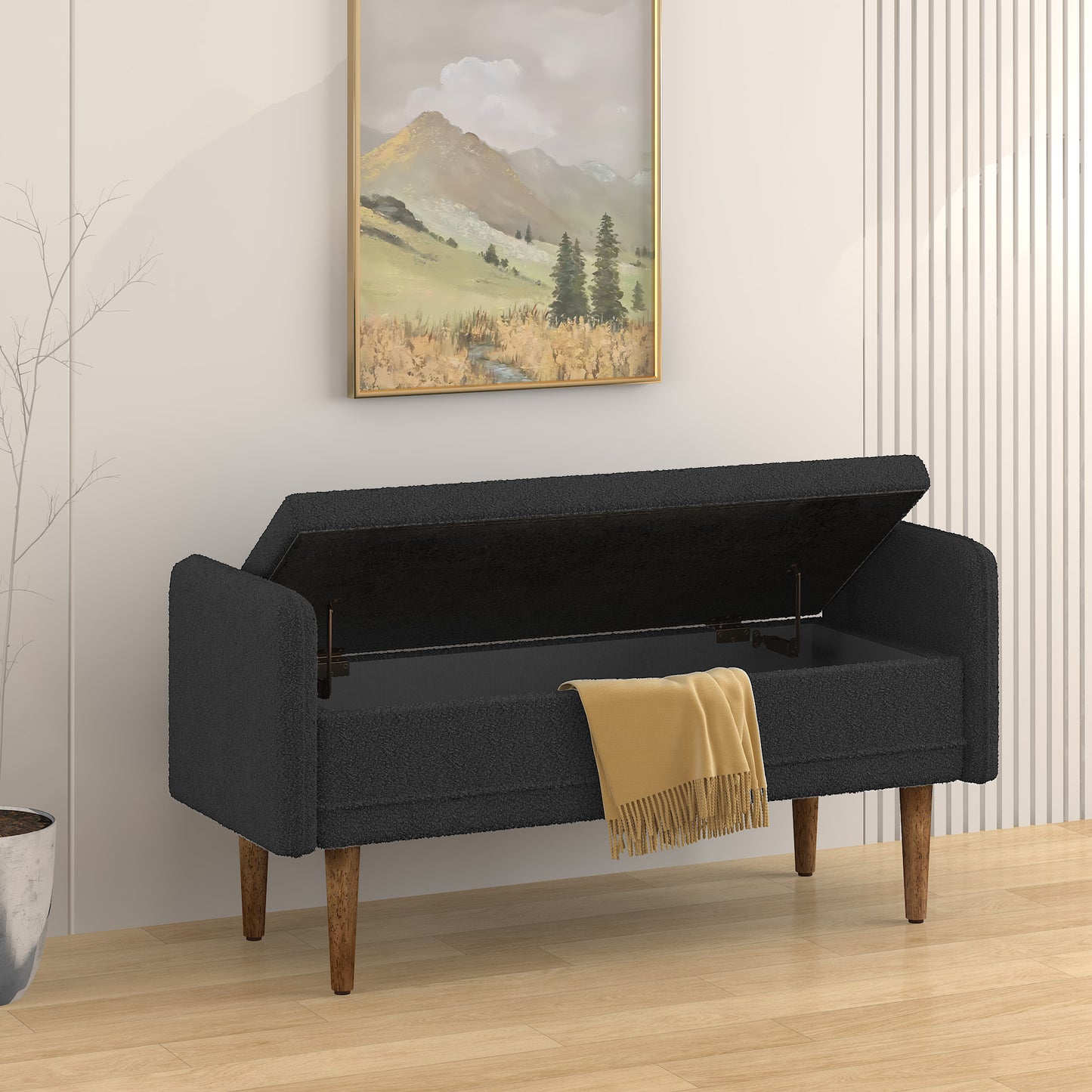 Dark grey boucle storage bench with open lid and yellow throw