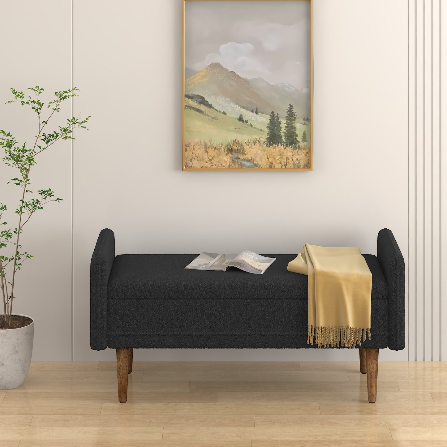 Black boucle storage bench with wooden legs and gold framed landscape art