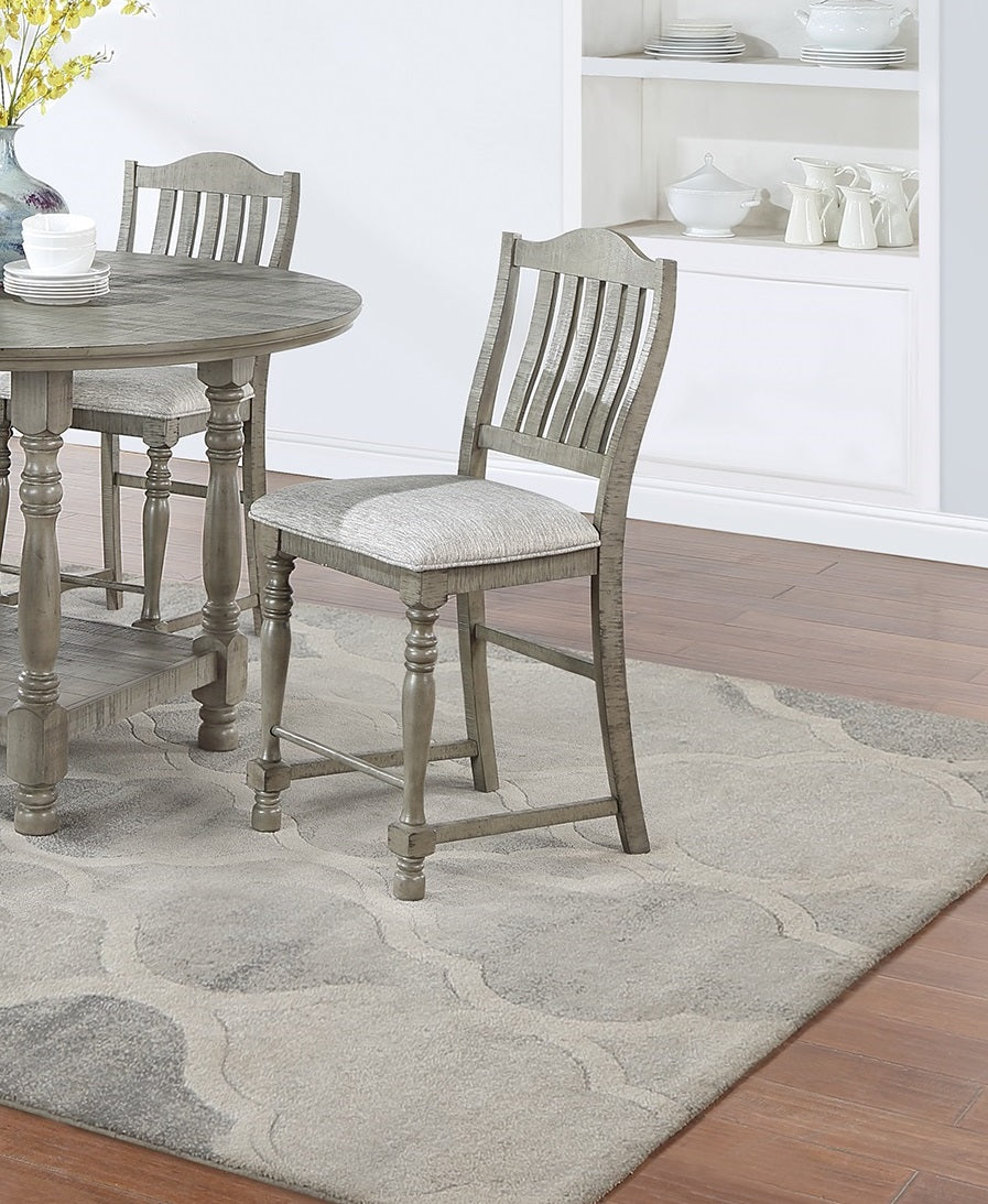 Gray wood counter stool with slatted back and upholstered seat on patterned rug