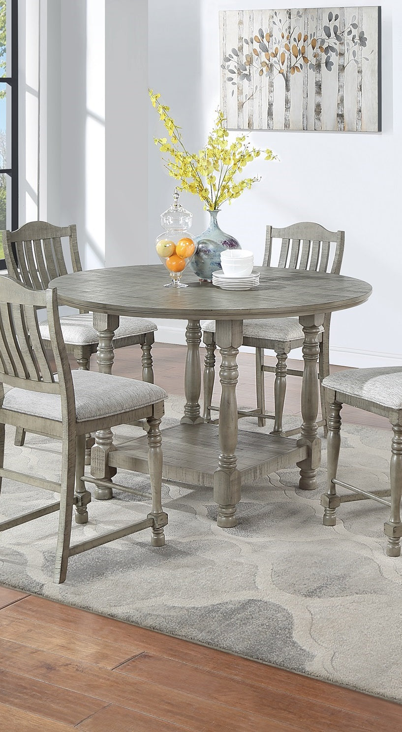 Round gray counter height dining table with four upholstered chairs