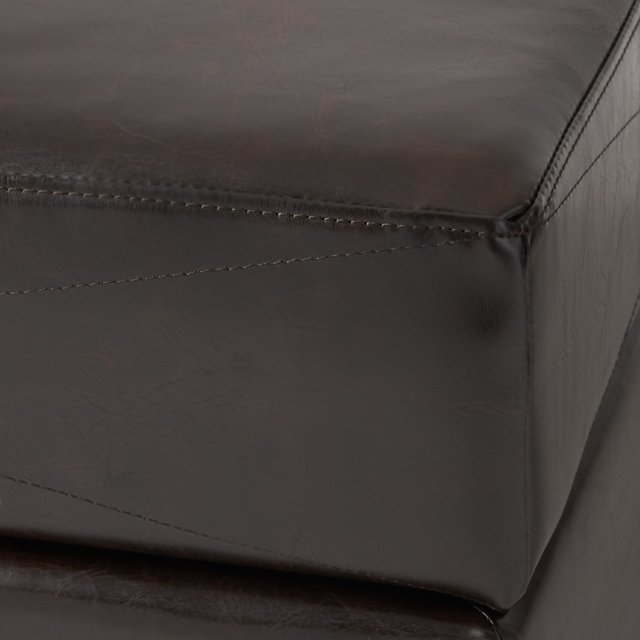 Dark brown faux leather ottoman corner with visible stitching