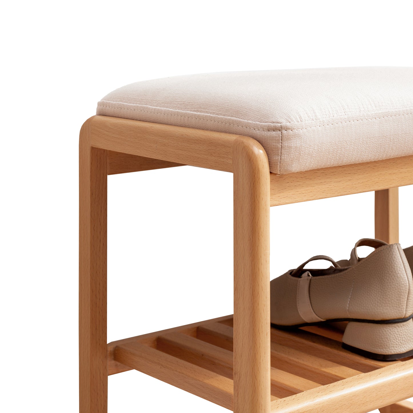 Natural wood shoe bench with beige fabric cushion and beige flat womens shoes