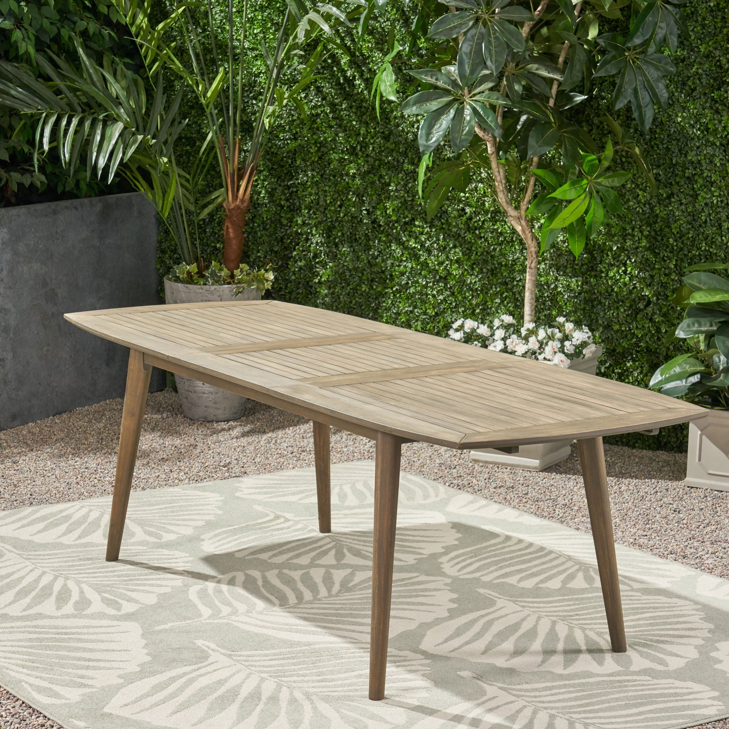 Rectangular wood dining table with slatted top and angled legs for outdoor patio