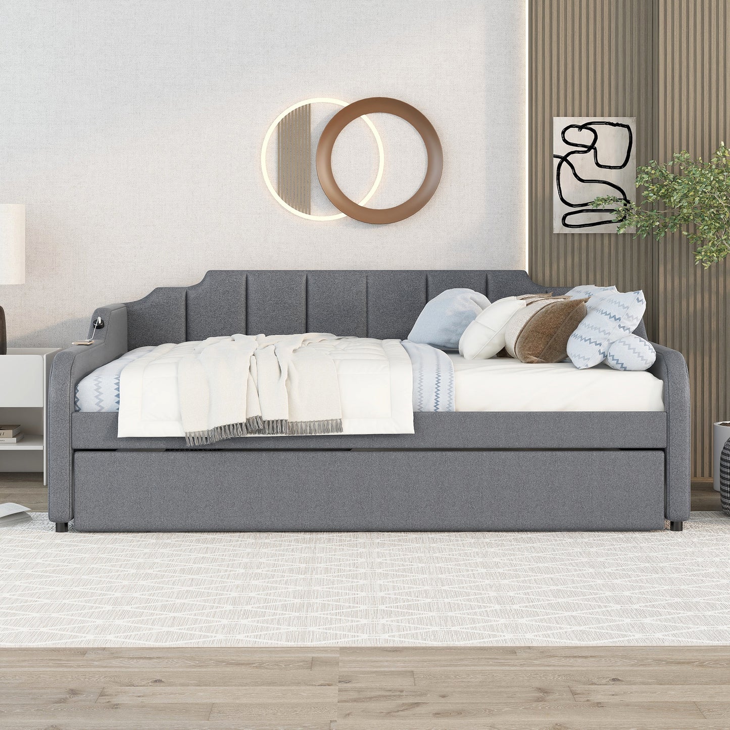 Gray upholstered daybed with tufted backrest and pullout trundle
