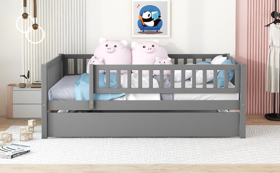 Gray wooden toddler bed with trundle and guardrails featuring pink pig pillows and blue bedding