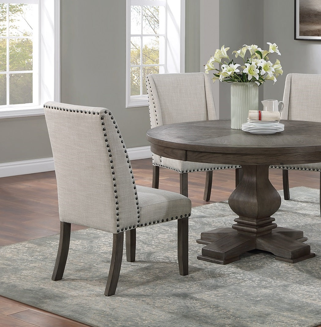 Tufted upholstered dining chair in beige linen with nailhead trim and dark wood legs