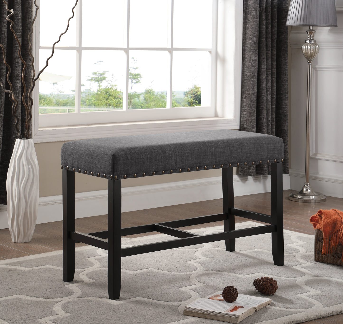 Dark gray upholstered counter stool with nailhead trim and dark wood legs
