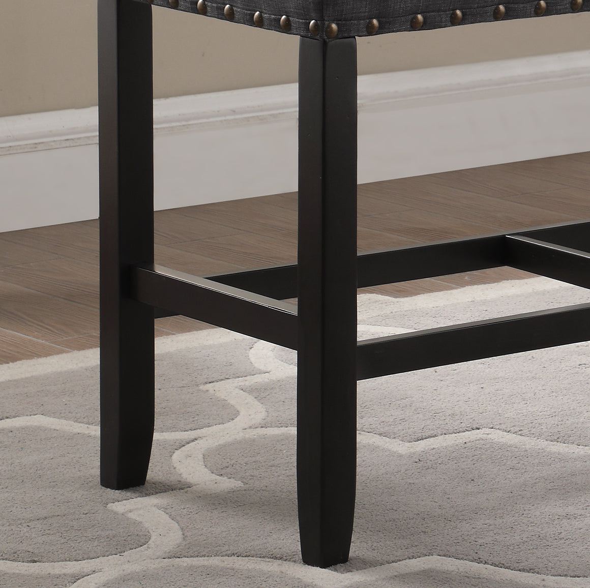 Dark grey upholstered stool legs with brass nailhead trim