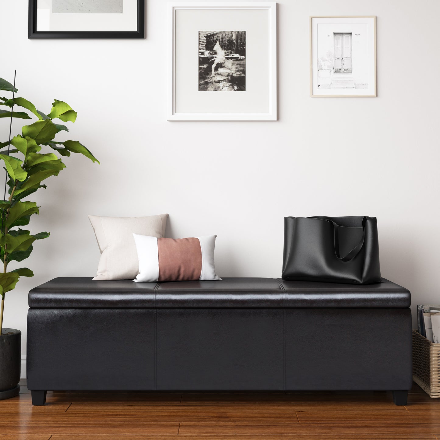 Black faux leather storage ottoman with plush pillows and tote bag