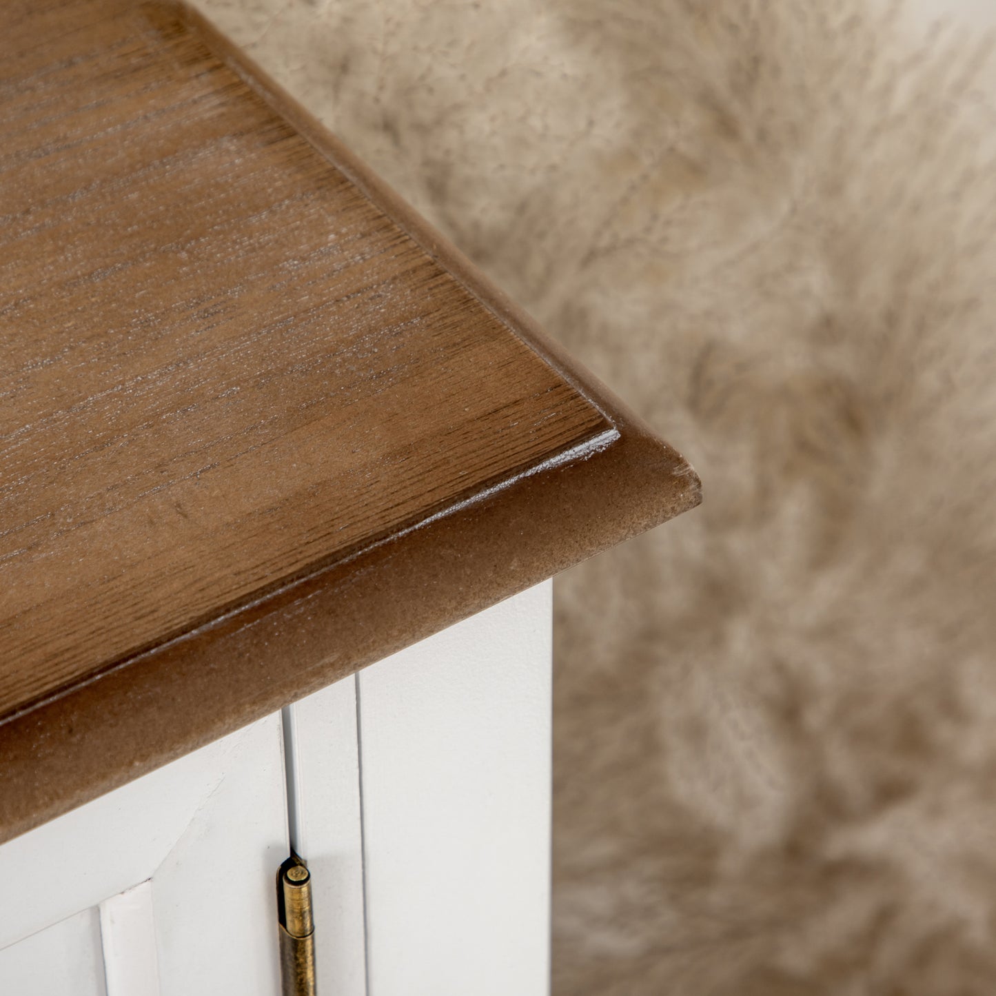 Rustic wood top on a white cabinet with antique brass hinge