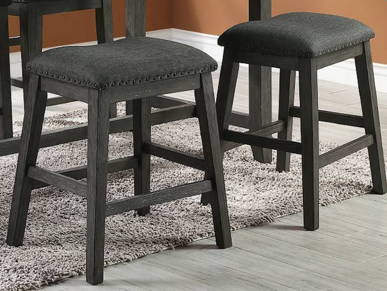 Dark gray upholstered counter stool with nailhead trim