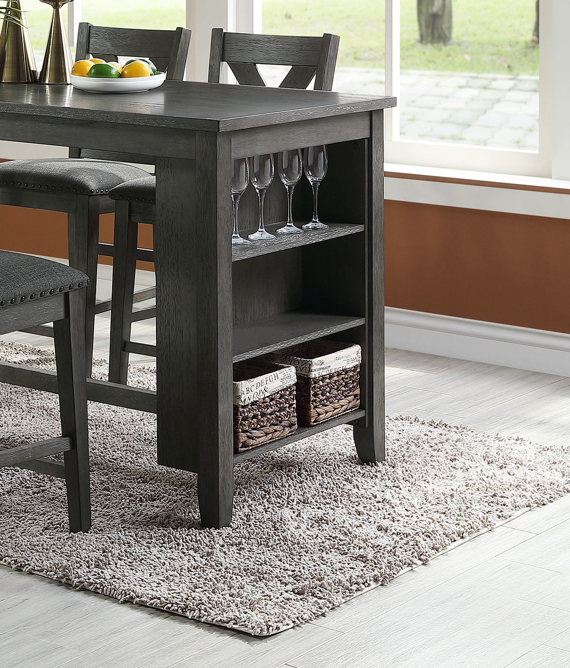 Dark gray wood counter height table with upholstered stools and builtin wine glass rack