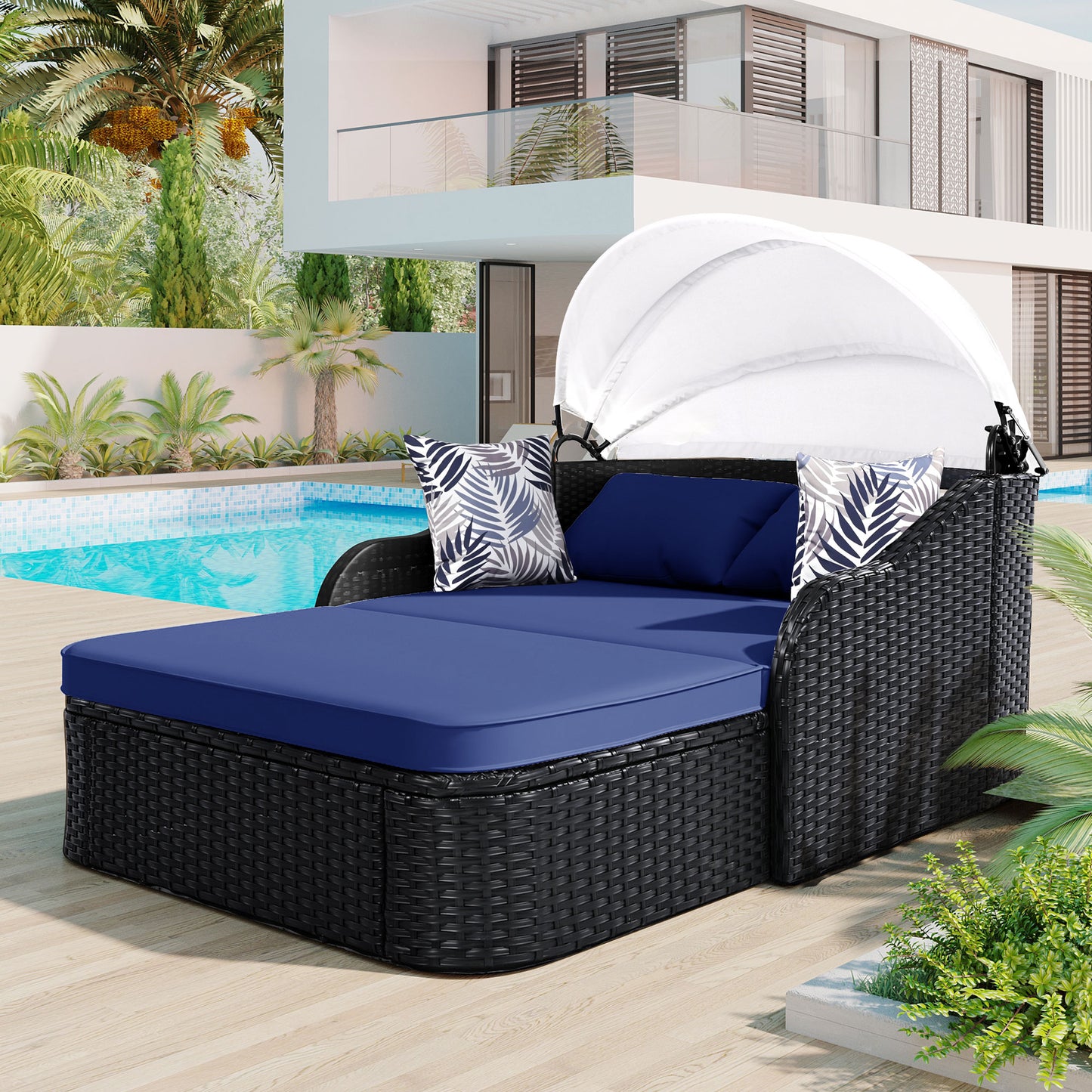 Black wicker daybed with navy cushions and palmleaf accent pillows