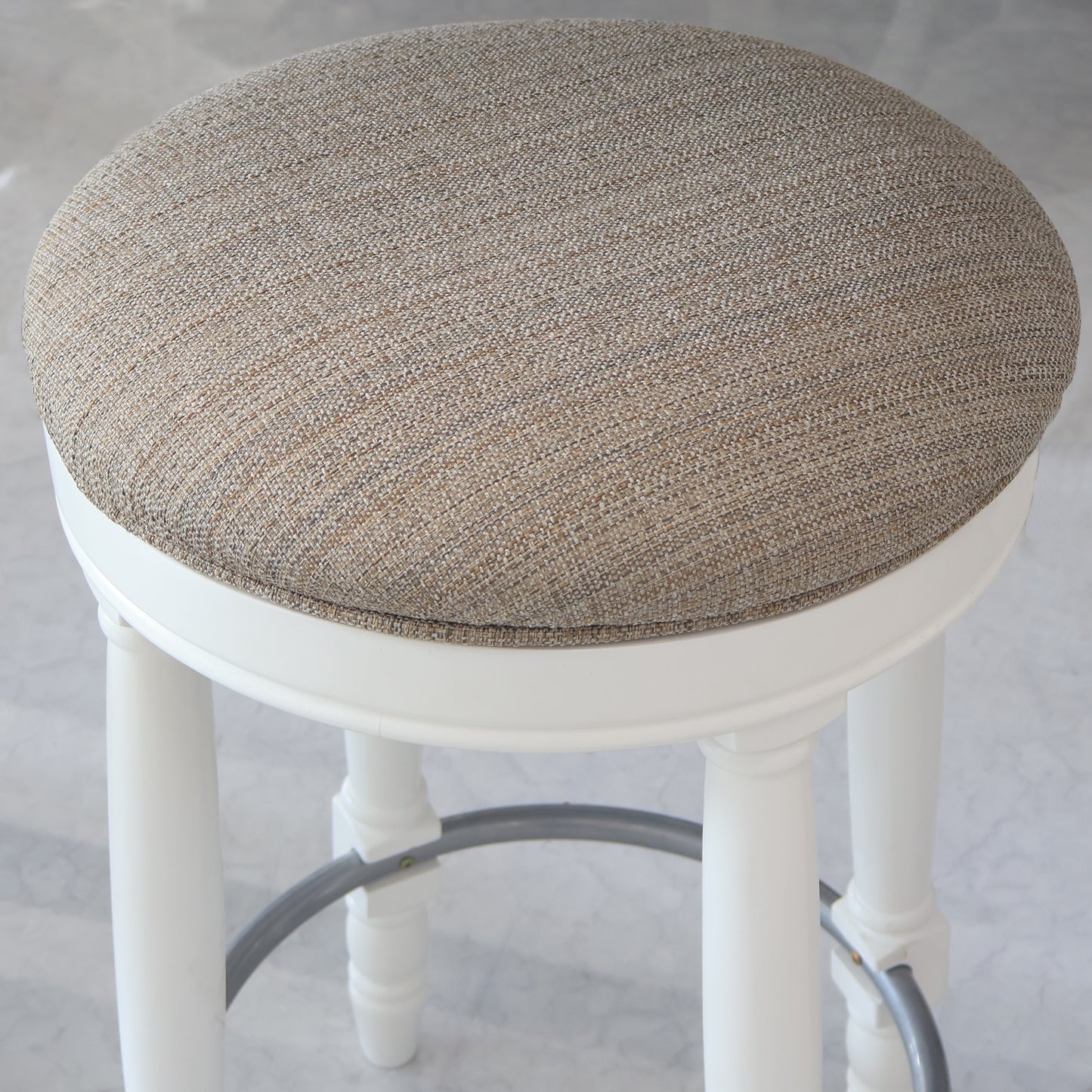 Cream textured fabric upholstered stool with white carved legs