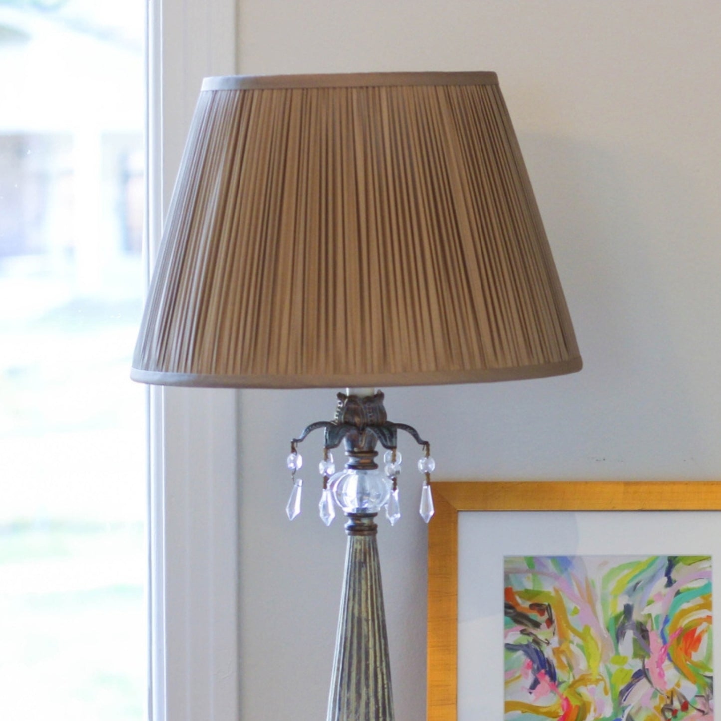 Antique brass table lamp with pleated tan shade and crystal accents