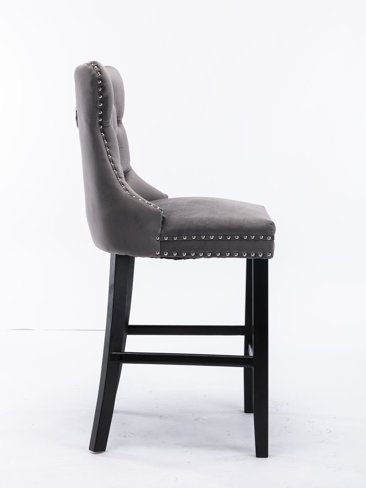 Gray velvet tufted bar stool with silver nailhead trim and black wooden legs