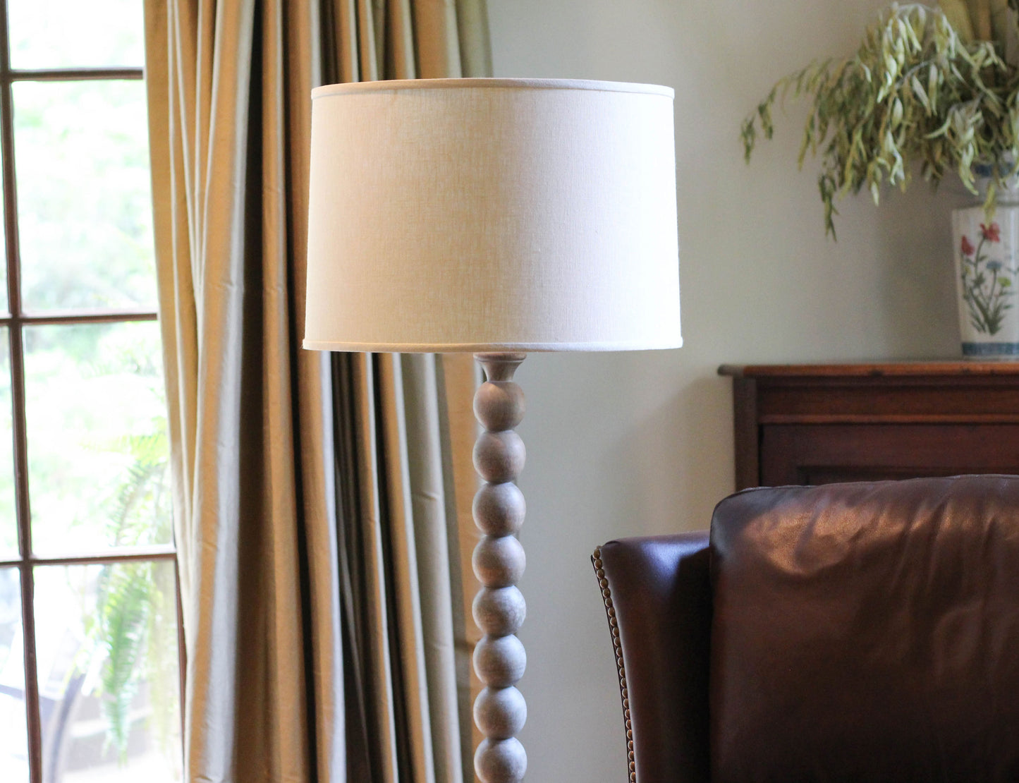 Modern wooden floor lamp with white drum shade and stacked spherical base