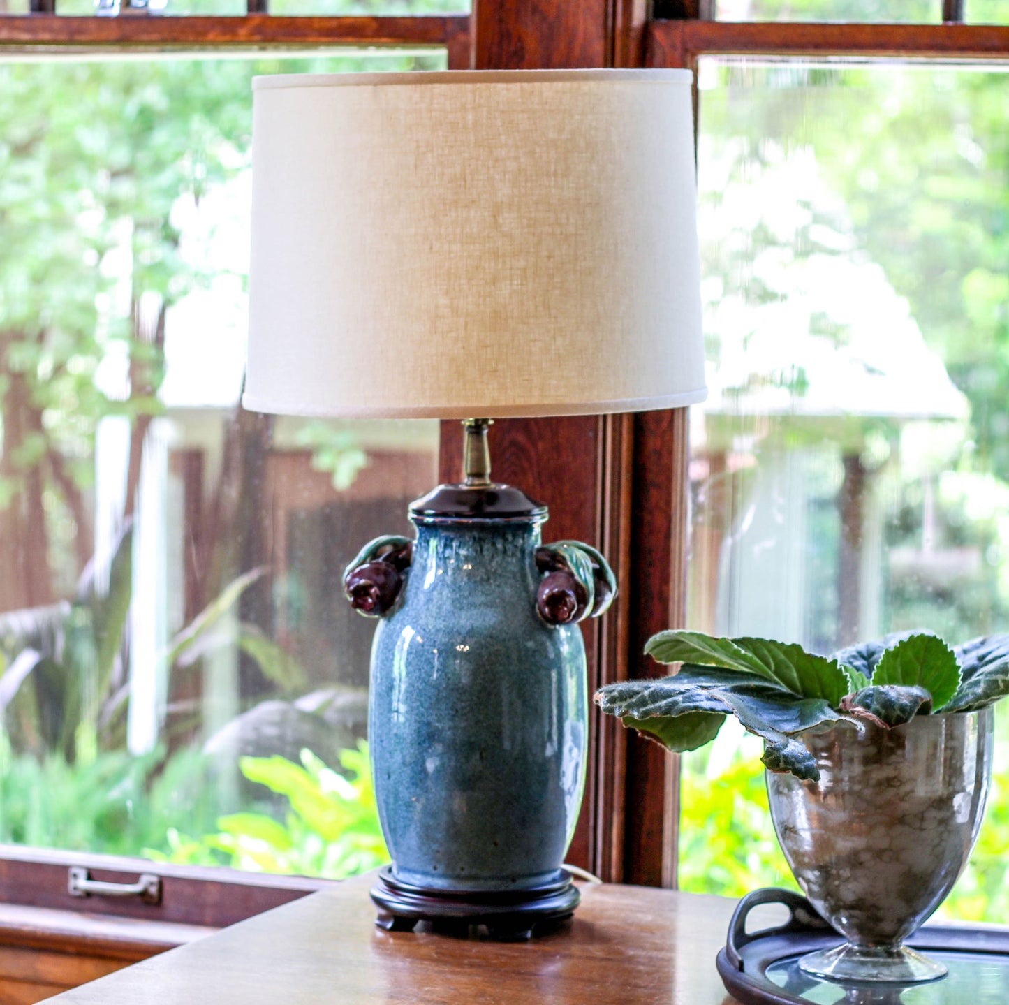 Blue ceramic table lamp with ornate handles and cream linen shade