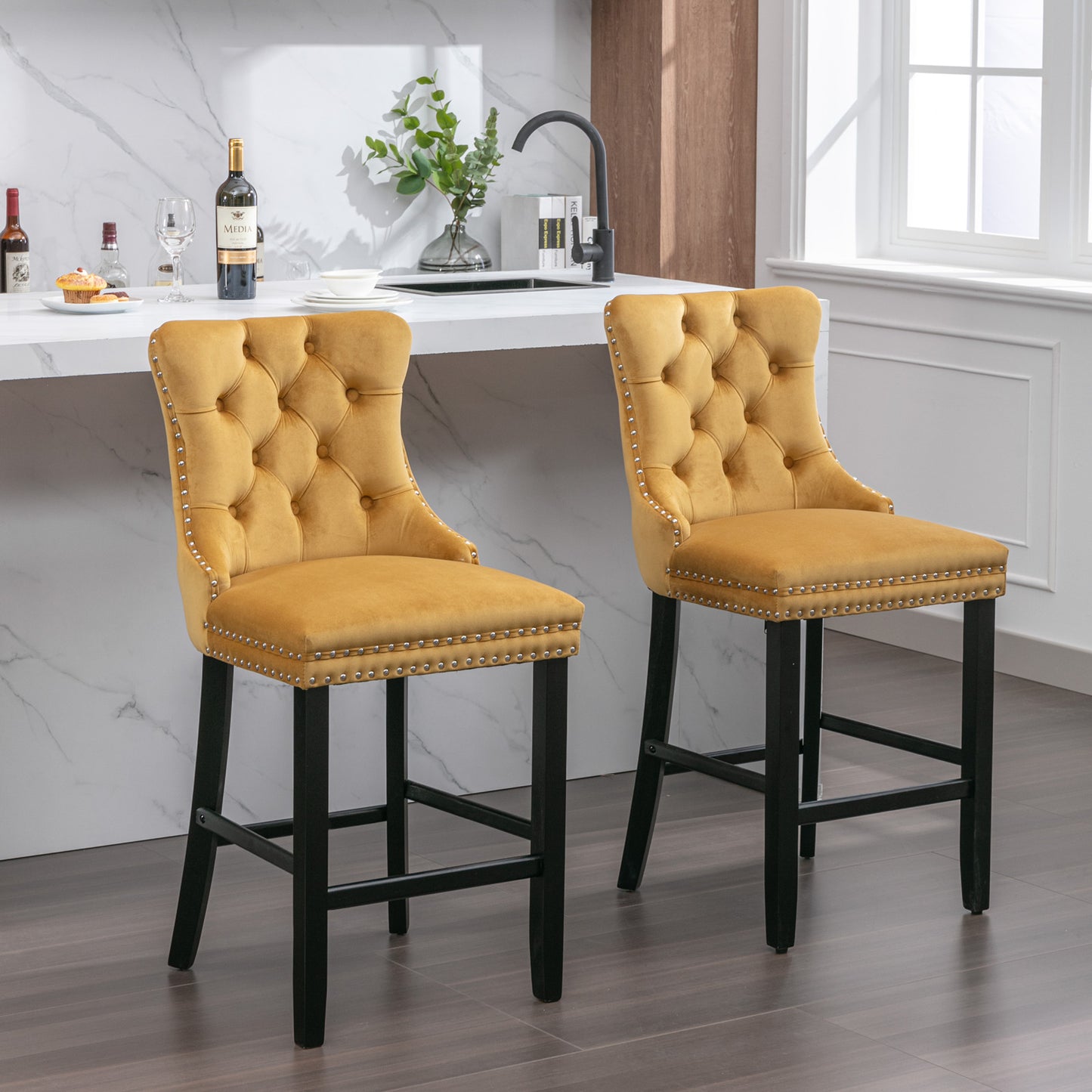 Two yellow velvet bar stools with tufted backs and silver nailhead trim