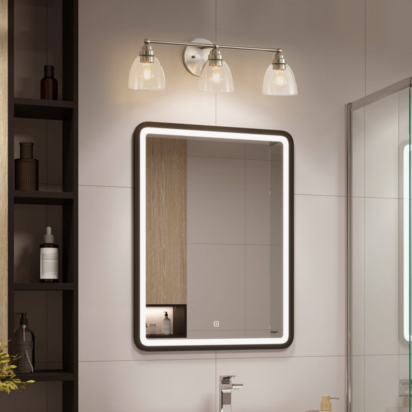 Brushed nickel vanity light with three clear glass shades illuminating a modern bathroom