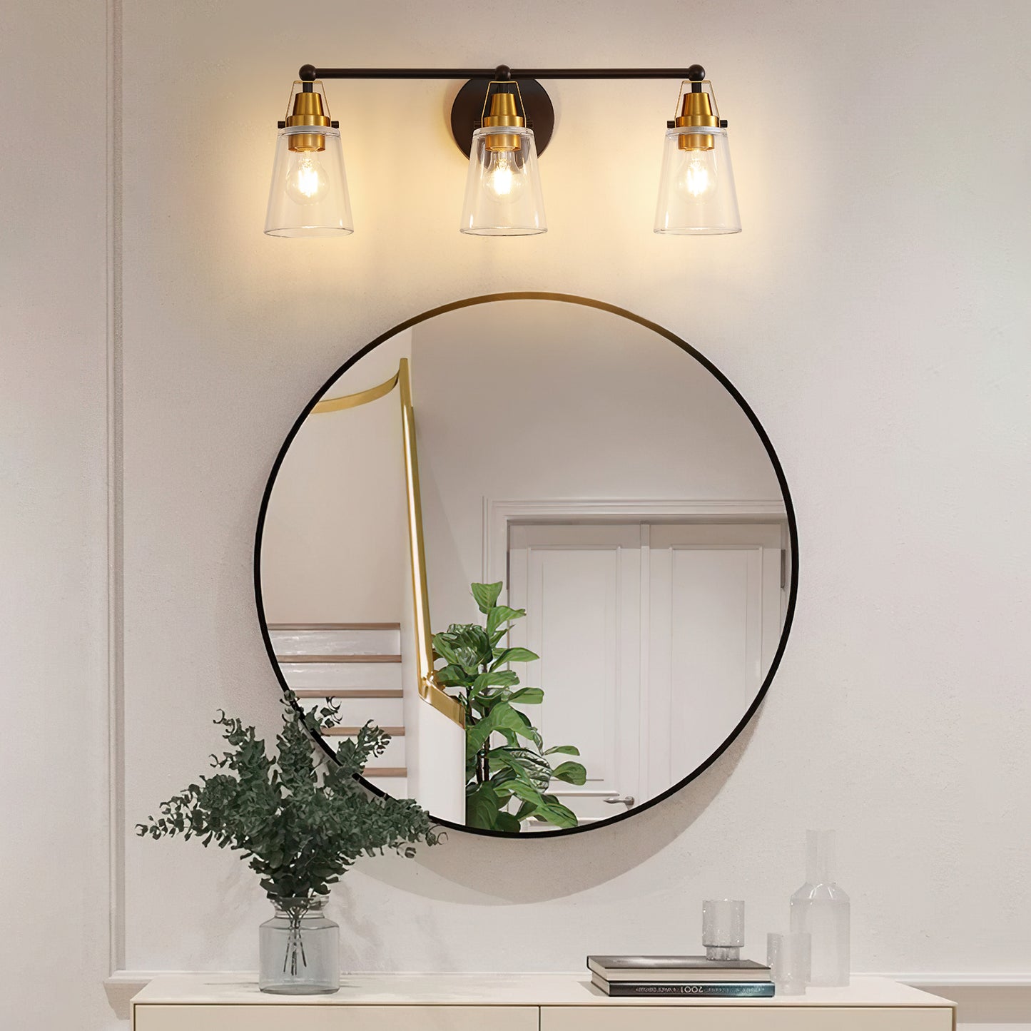 Black metal vanity light with three clear glass cone shades and brass accents