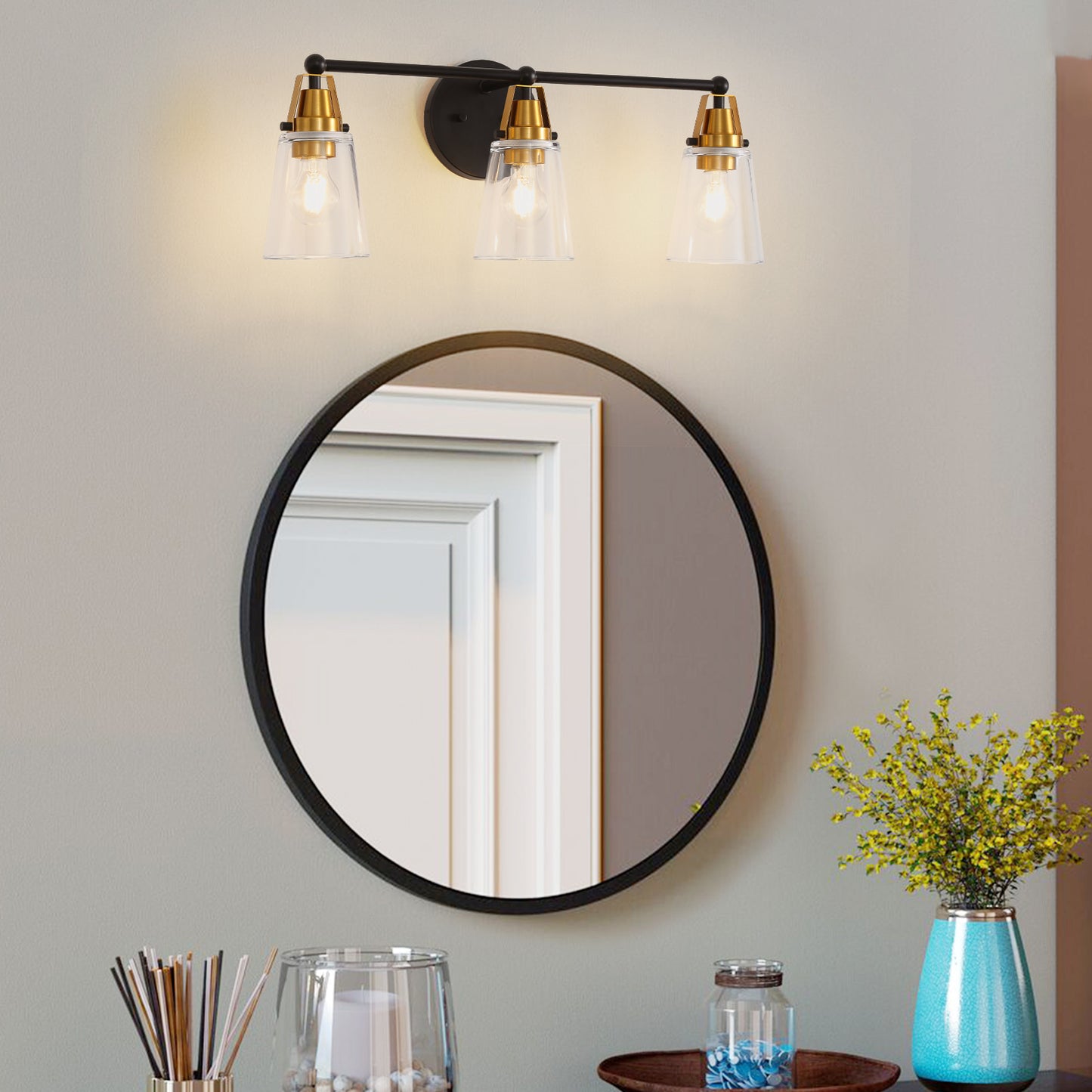 Black modern vanity light fixture with three clear glass cone shades and brass accents