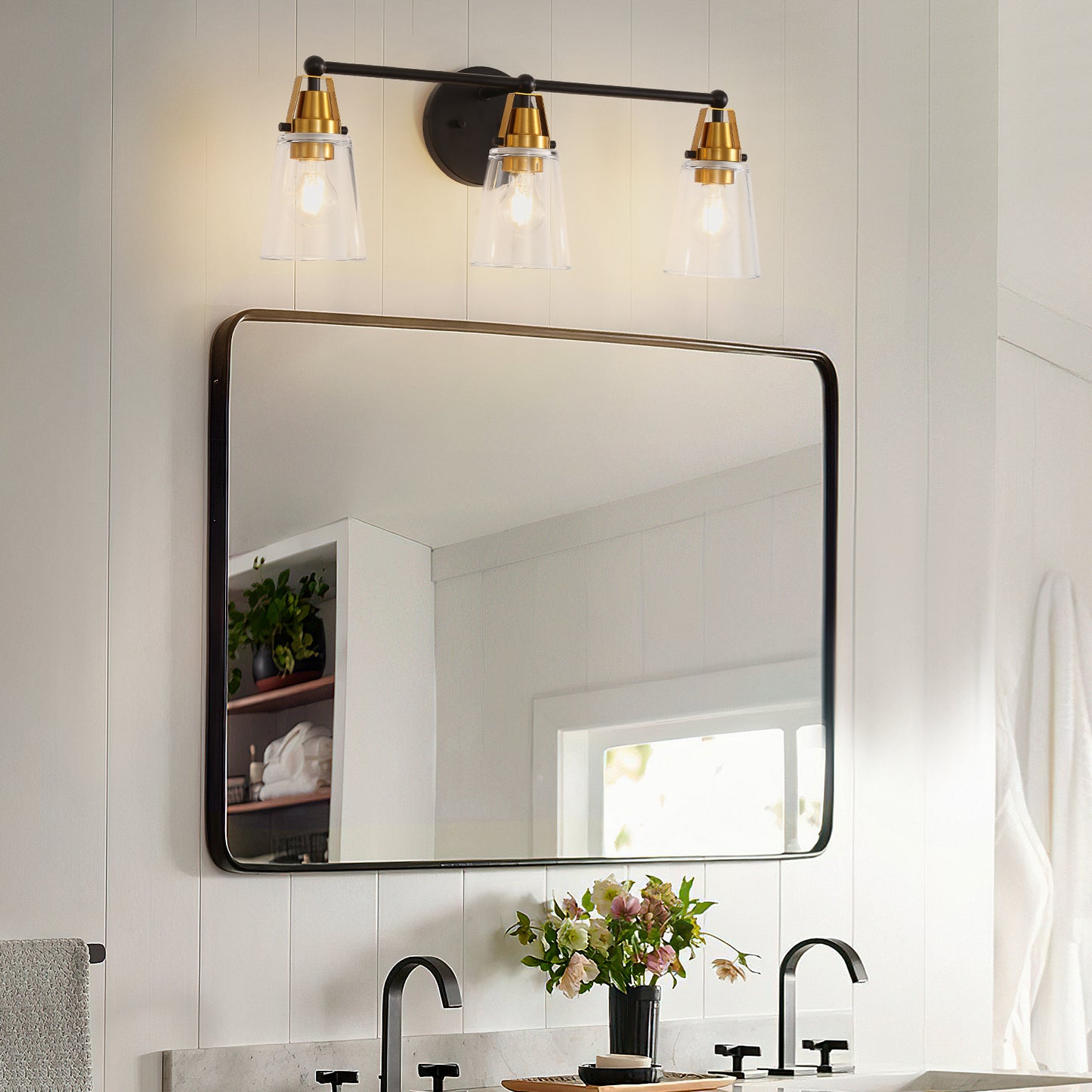 Black and brass threelight vanity light with clear glass shades