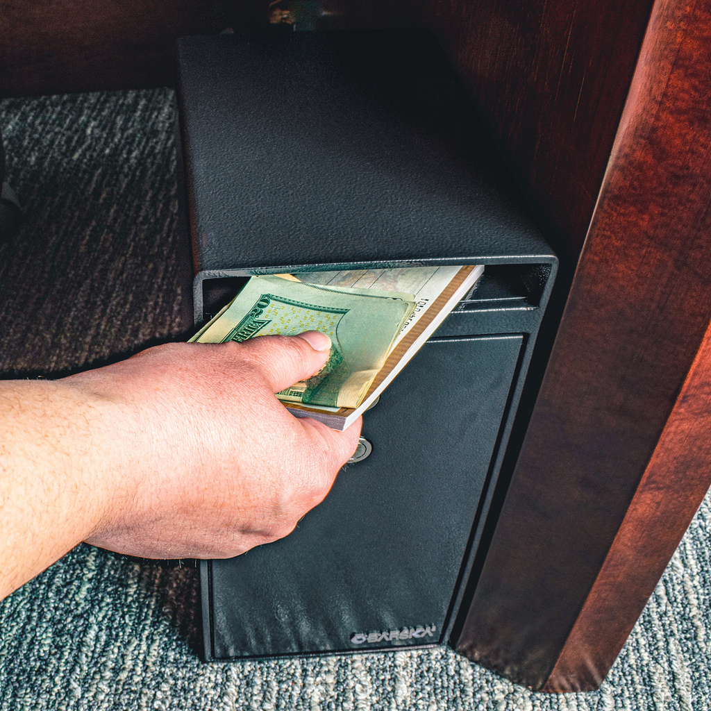 Black steel floor safe discreetly stores cash under desk