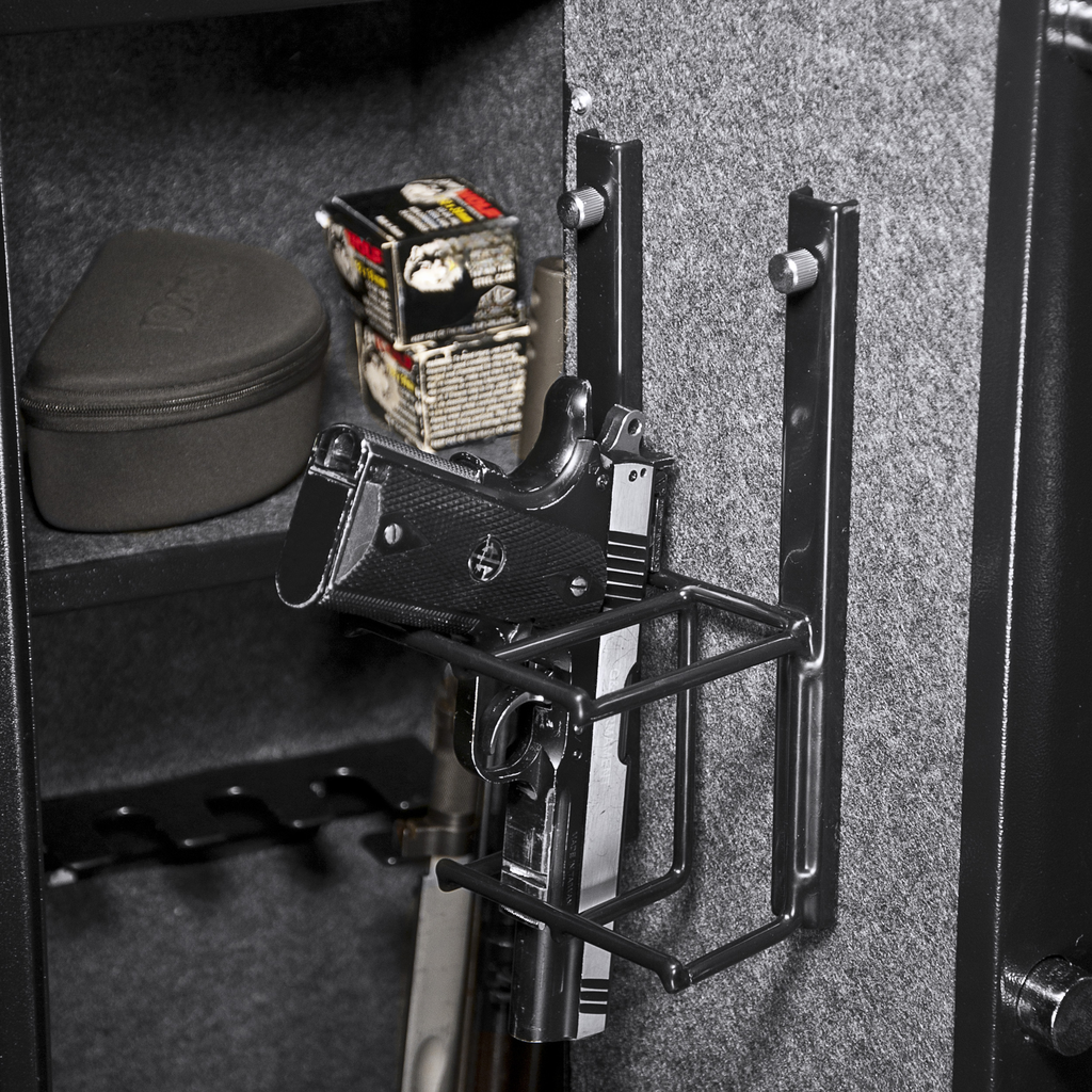 Black handgun held in a metal gun rack inside a safe