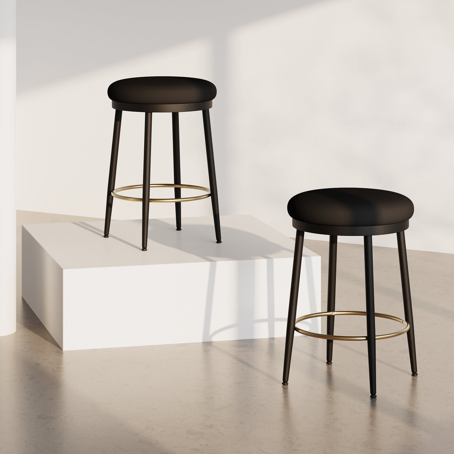 Black upholstered bar stool with gold footrest and tapered legs