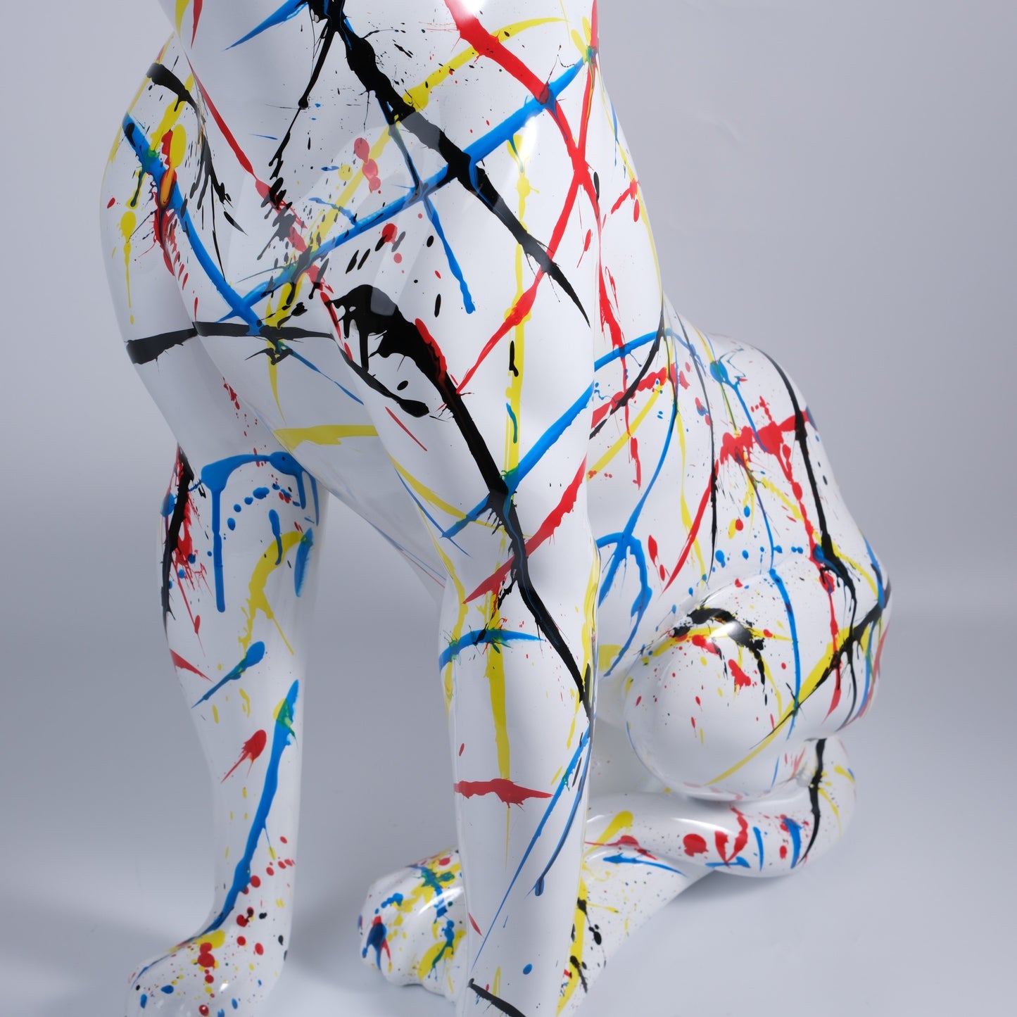 White resin dog statue with vibrant paint splatters