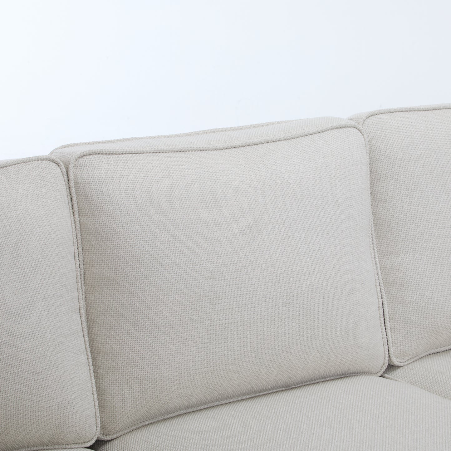 Cream textured fabric sofa cushions with piped seams