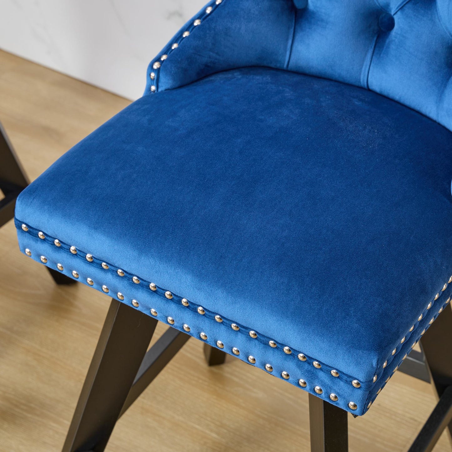 Tufted royal blue velvet bar stool with silver nailhead trim and dark wood legs