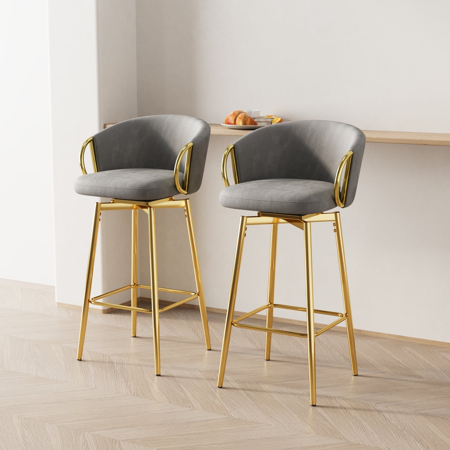 Two gray velvet bar stools with gold legs