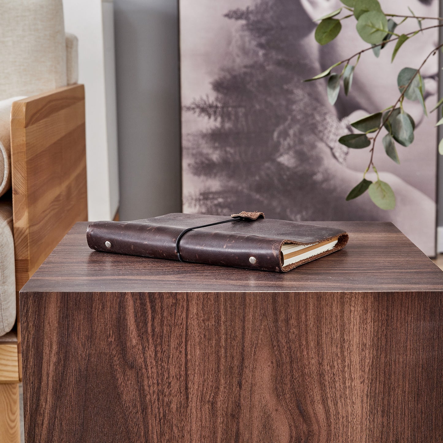 Dark brown leather journal with a wraparound strap and metal grommets