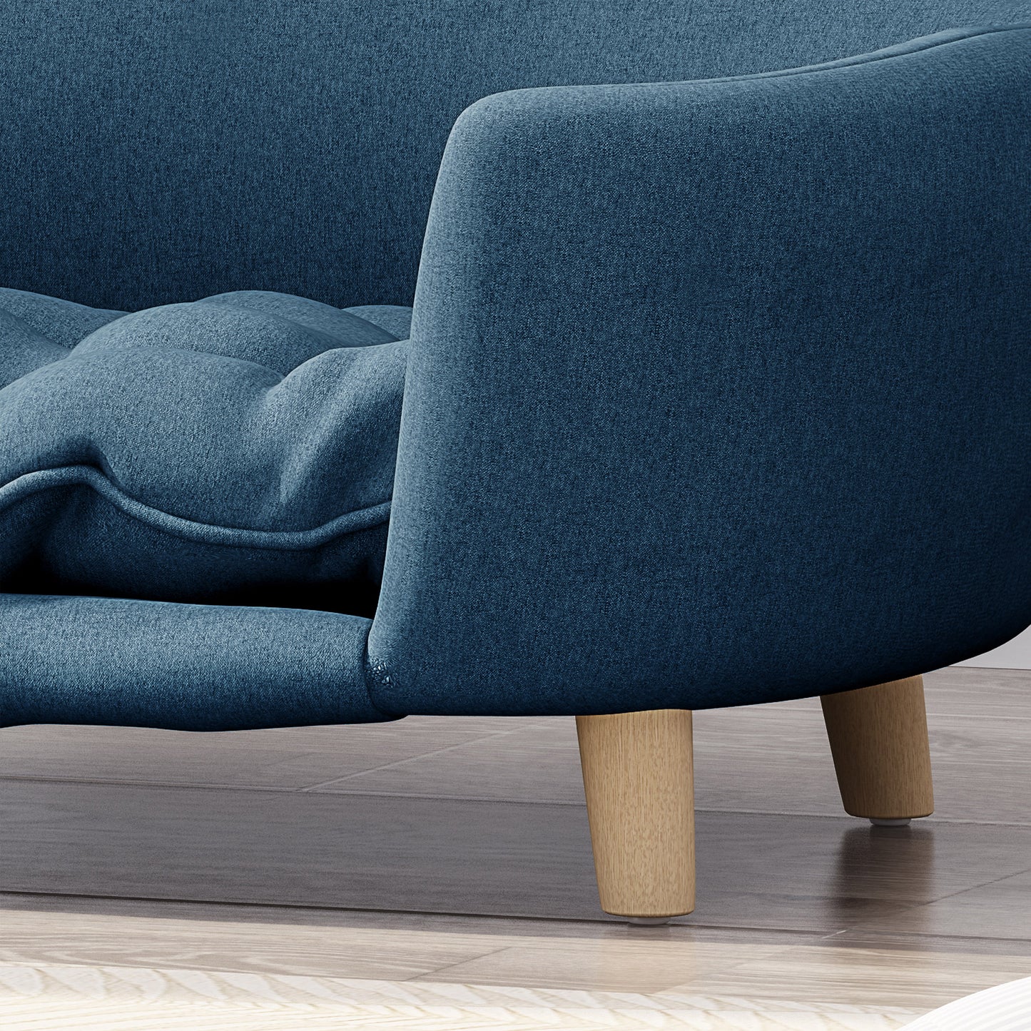 Close up of a navy blue fabric armchair with tufted seat cushion and wooden legs