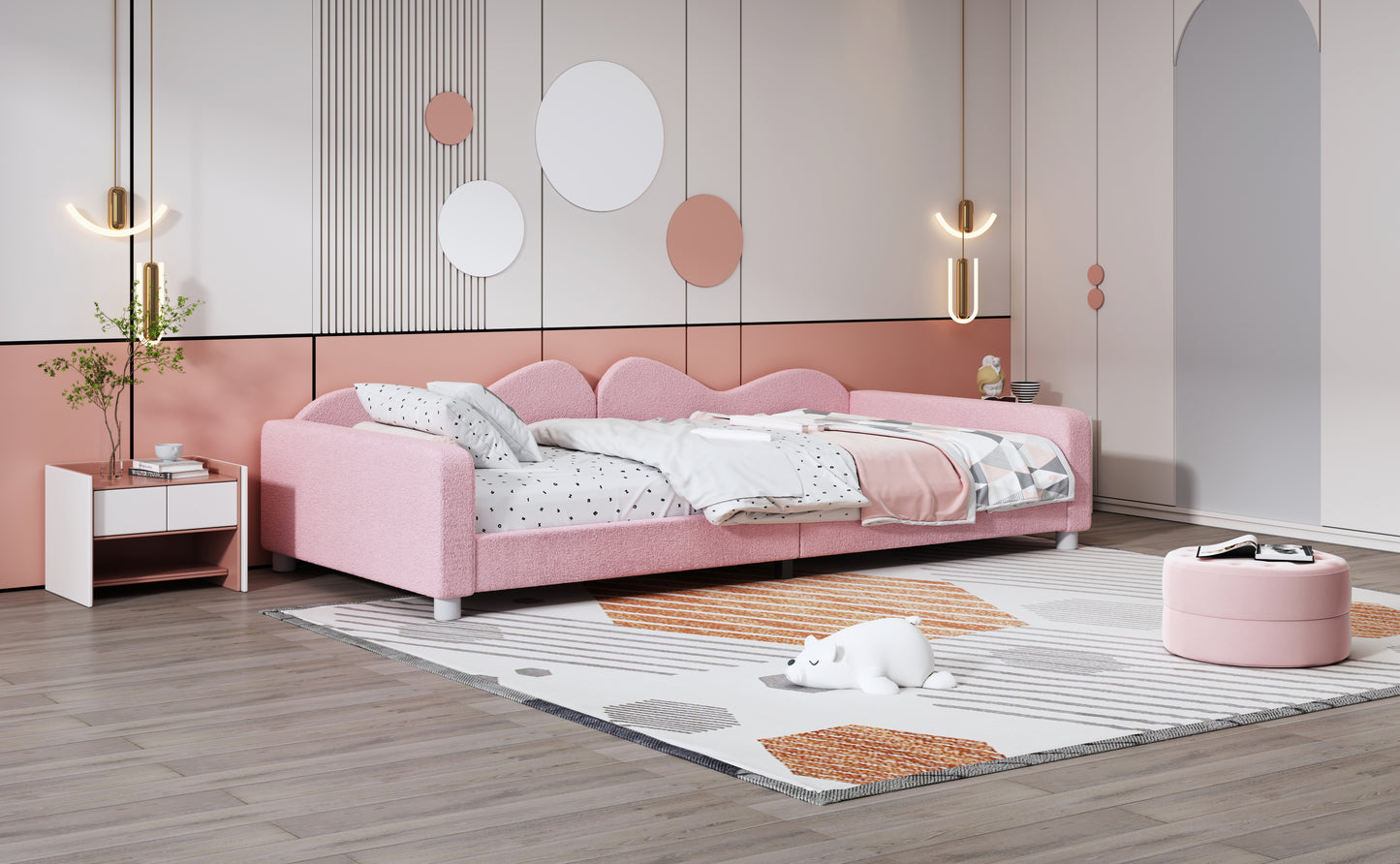 Pink upholstered twin daybed with wavy headboard and alphabet print bedding