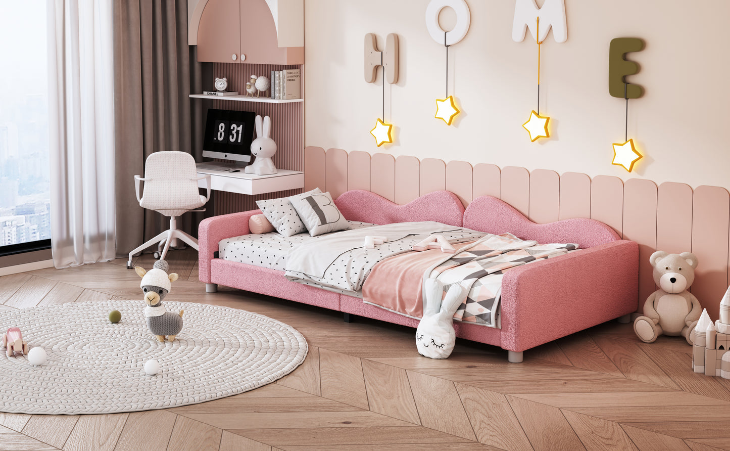 Pink toddler bed with plush bedding and playful pillows