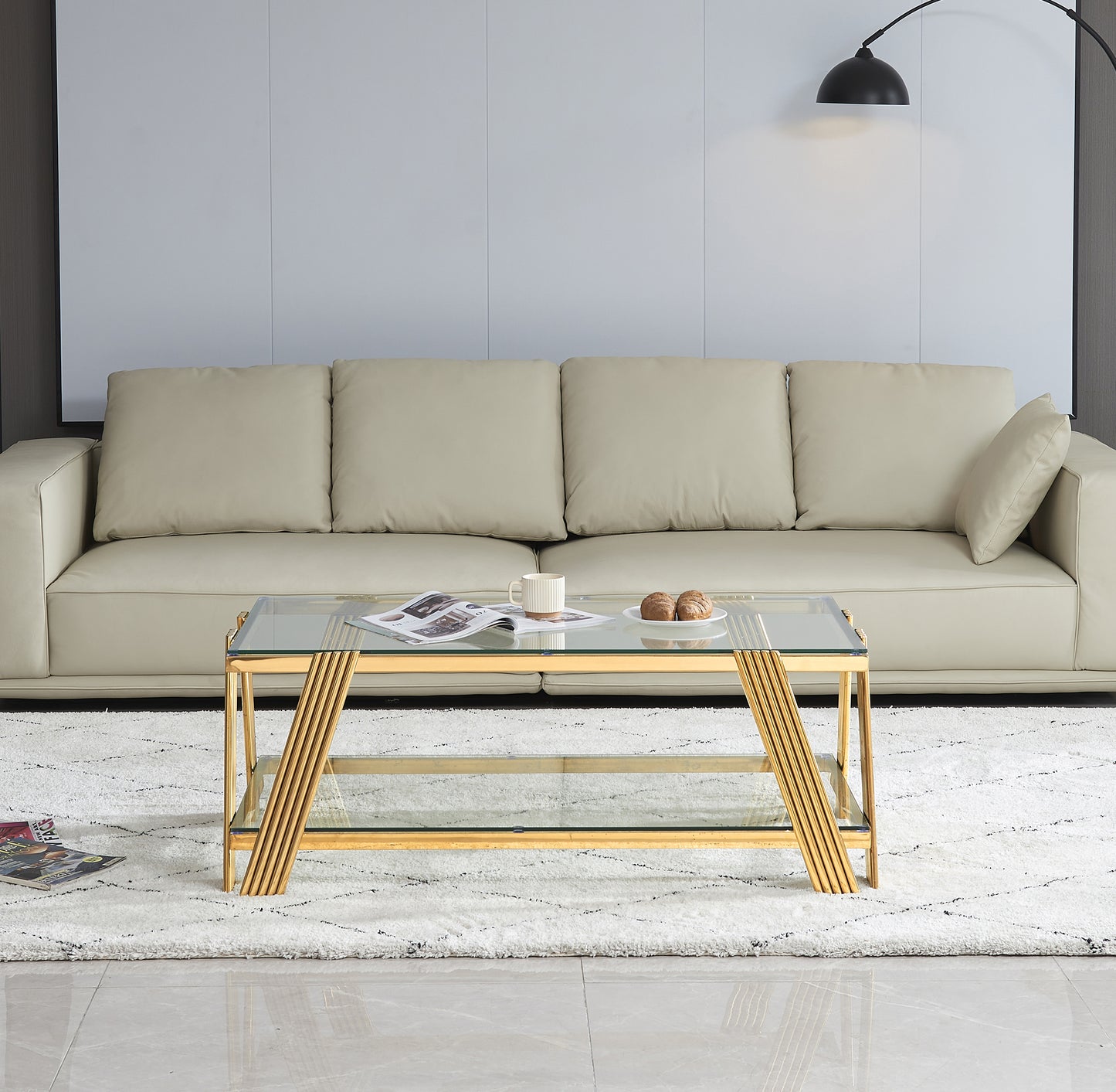Modern gold coffee table with glass top and shelf
