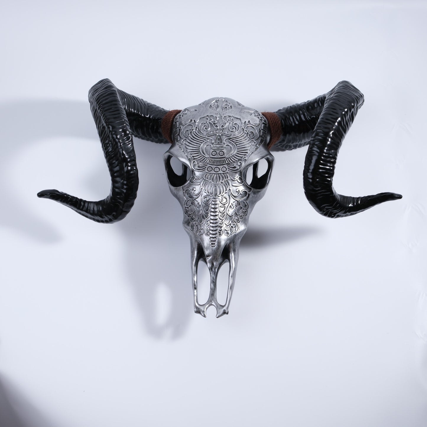 Ornate silver ram skull wall decor with glossy black horns