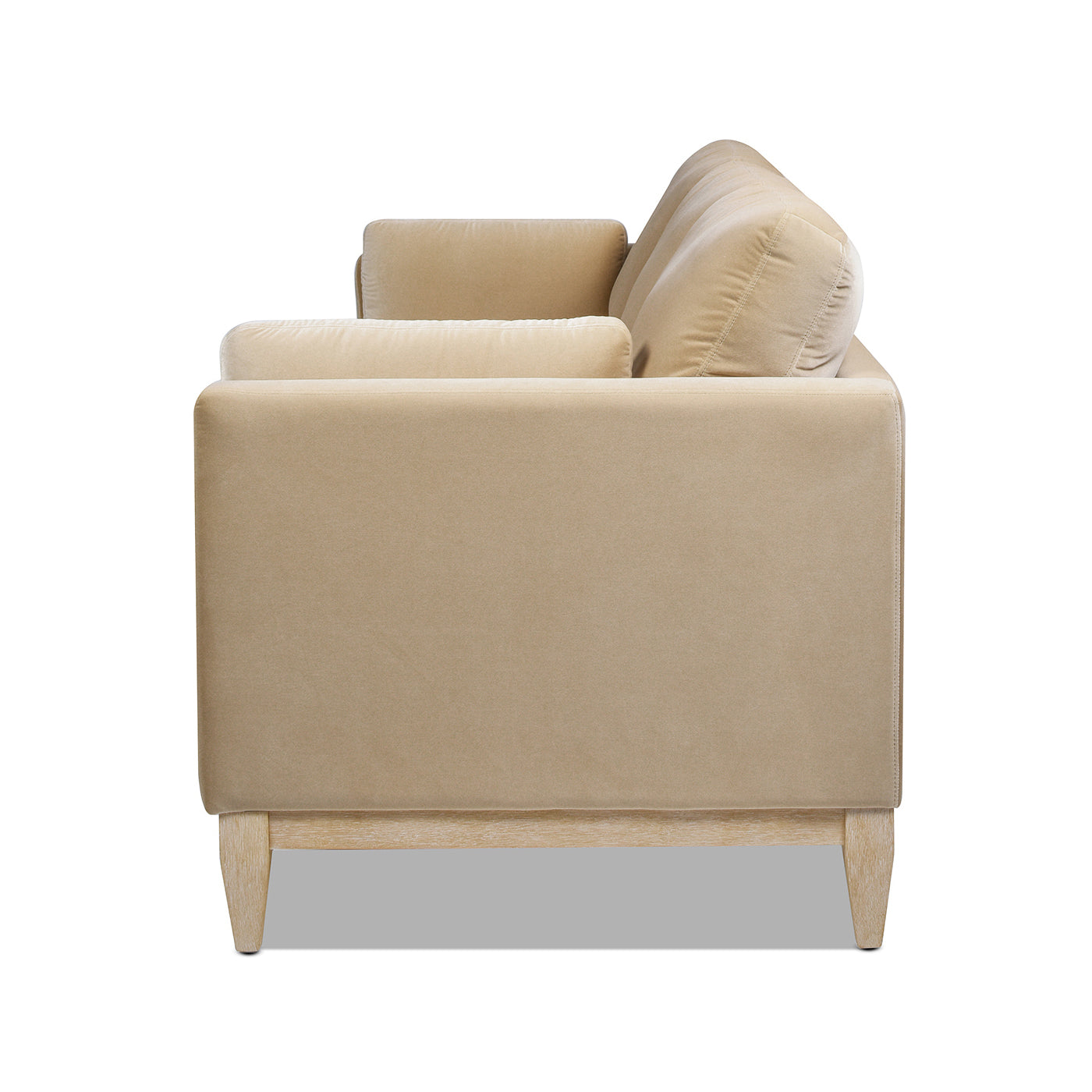Tan velvet sofa with plush cushions and light wood legs