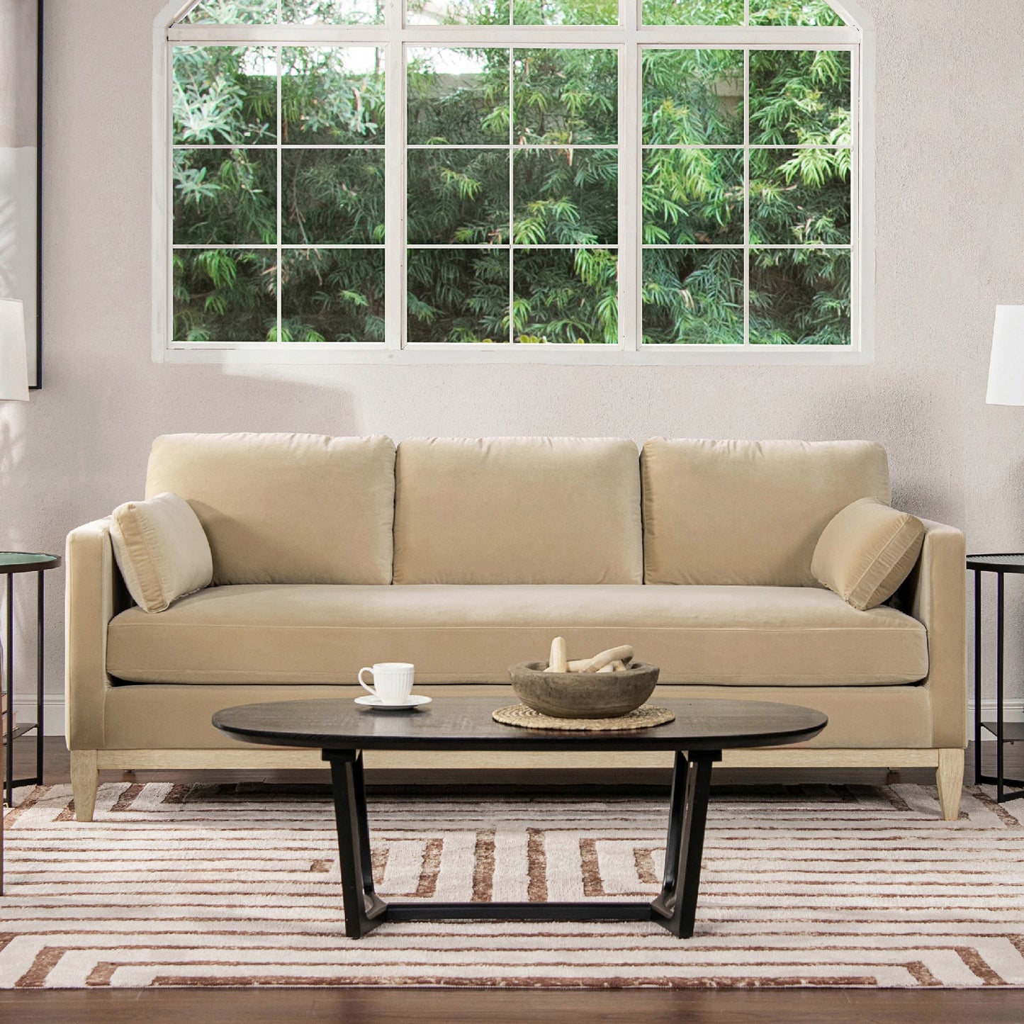 Elegant beige velvet sofa with plush cushions and wooden legs perfect for a living room setting