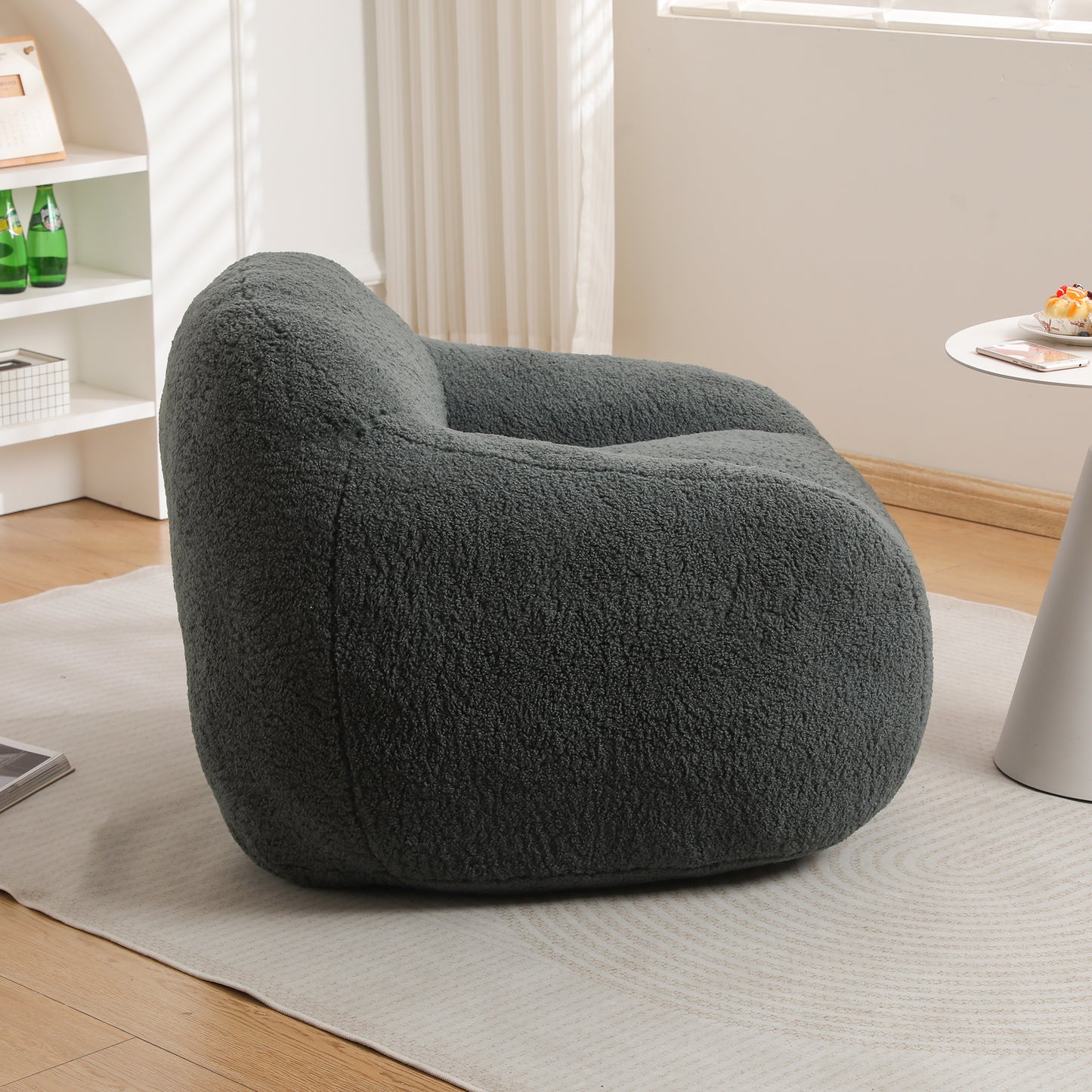 Dark gray plush armchair with rounded silhouette