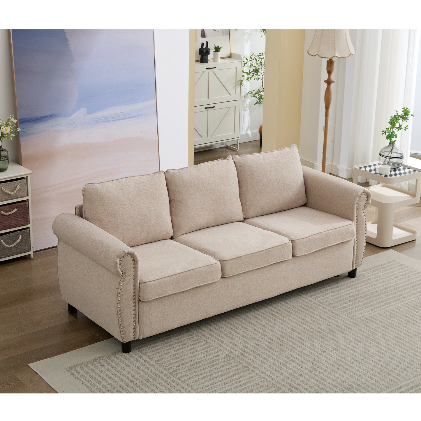 Beige upholstered threeseater sofa with studded armrests and plush cushions