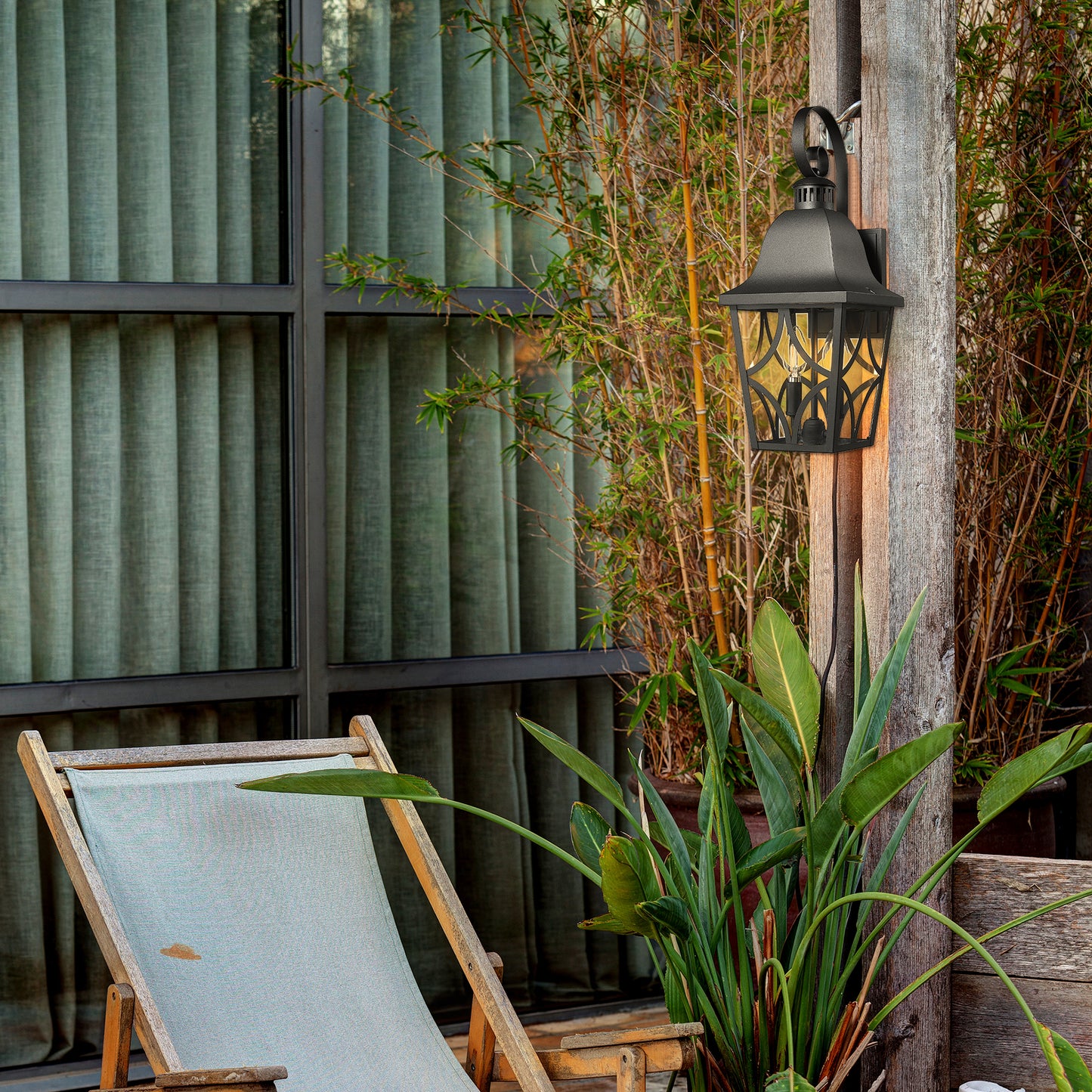 Black traditional outdoor wall lantern with ornate gold glass panels