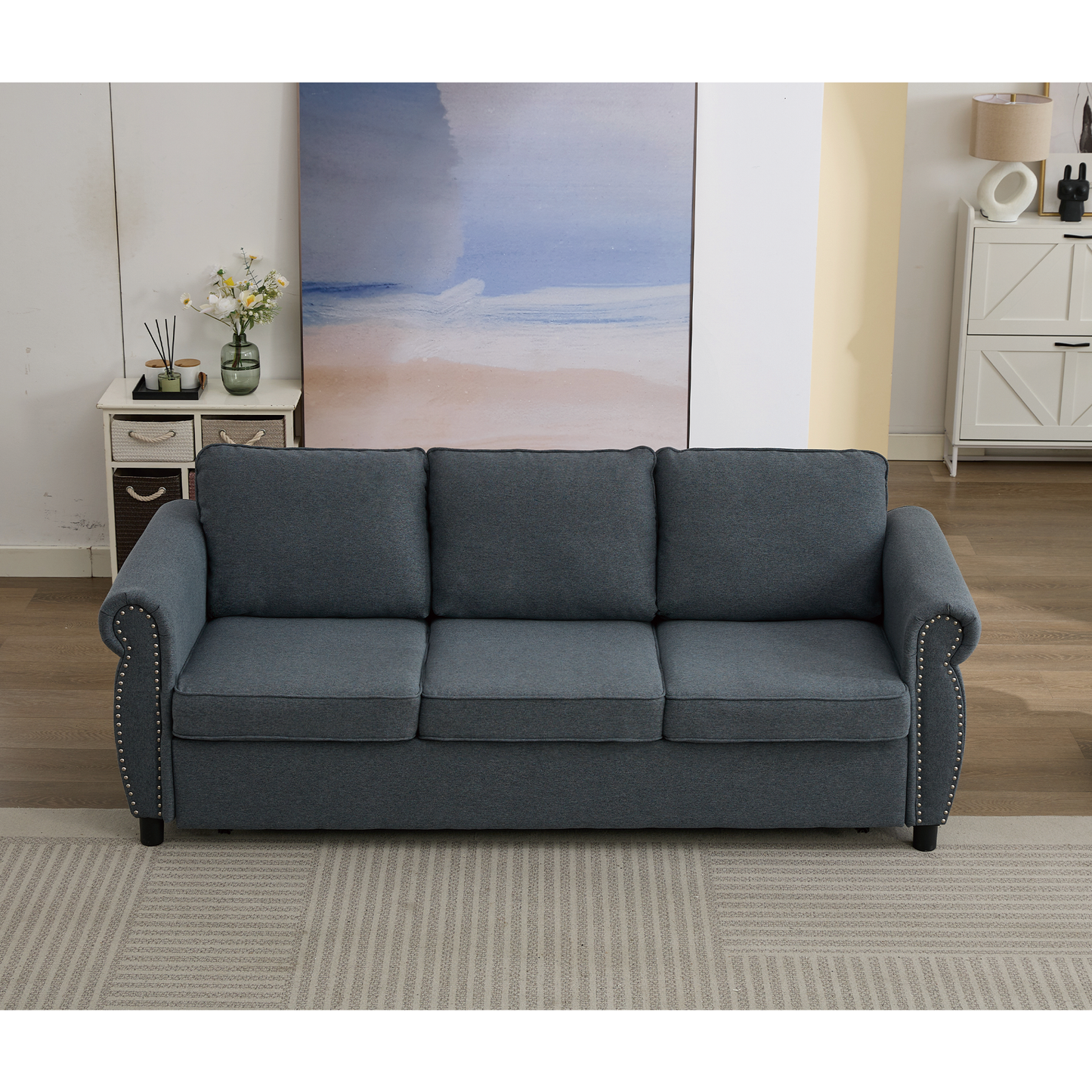 Dark grey fabric threeseater sofa with silver nailhead trim detail