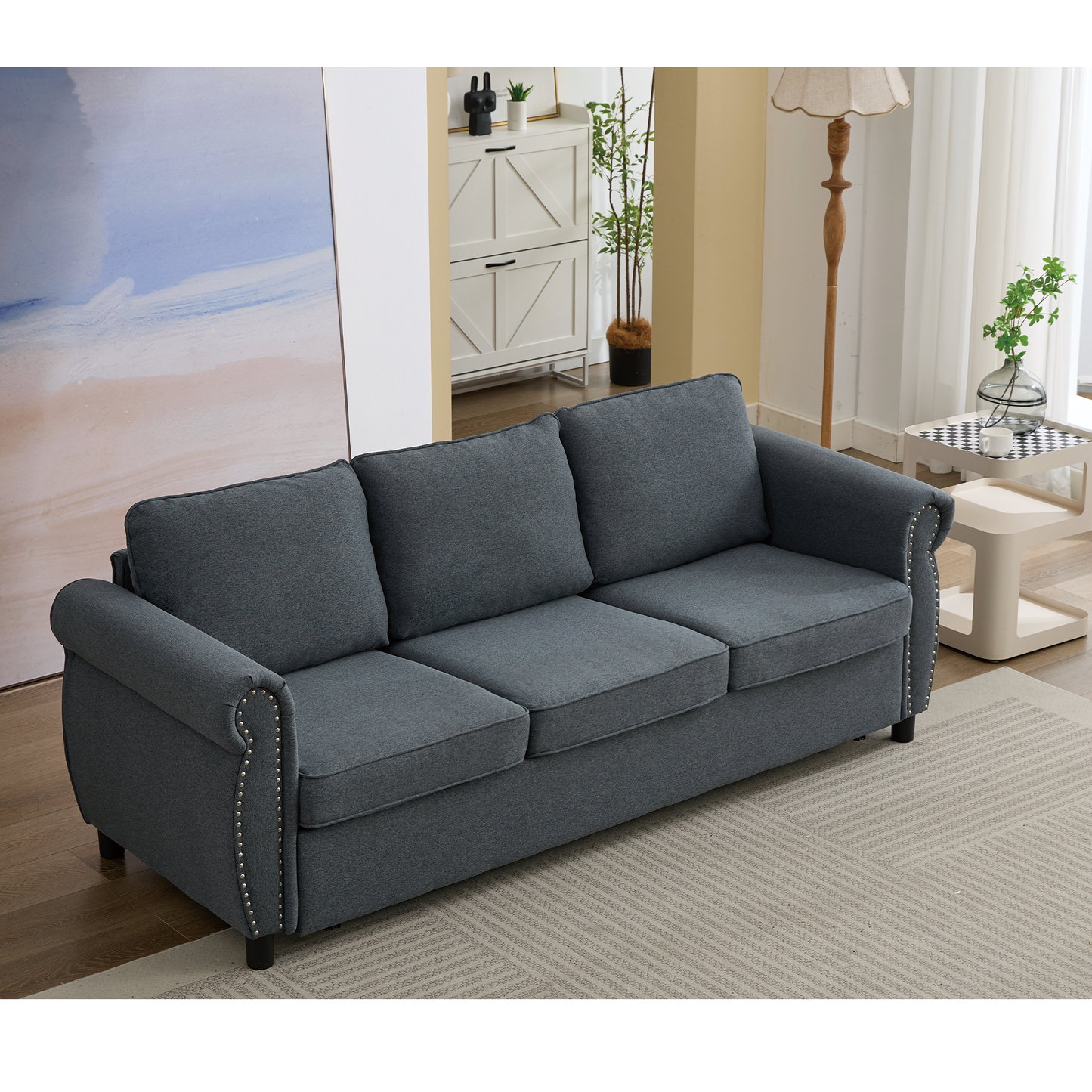 Dark gray fabric sofa with rolled arms and silver nailhead trim