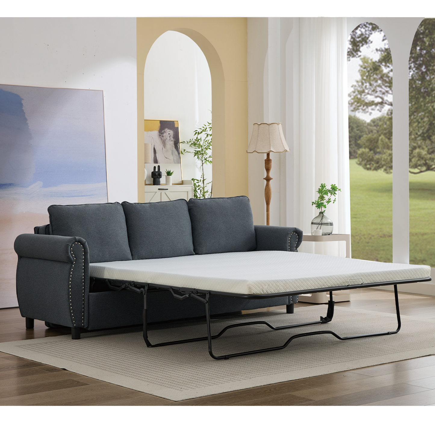 Dark gray fabric sofa bed with pullout mattress and studded trim