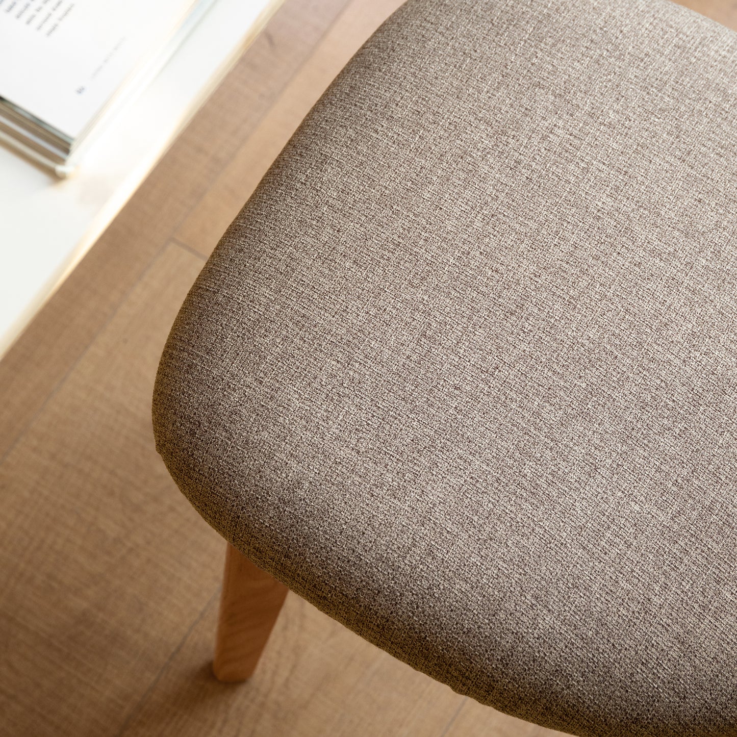Closeup of beige textured fabric seat on a modern dining chair